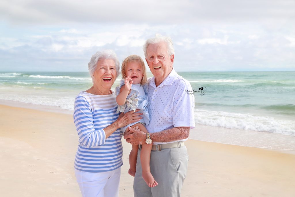 Family enjoying a joyful beach photography session, capturing candid moments of love, laughter, and togetherness by the ocean at sunset.