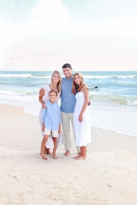 Joyful family playing by the ocean, captured in a scenic beach photography session.