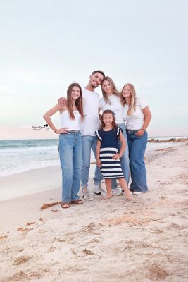 Family enjoying a joyful beach photography session, capturing candid moments of love, laughter, and togetherness by the ocean at sunset.