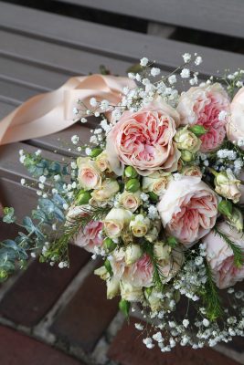 Close-up of an elegant bridal bouquet with soft roses and eucalyptus, photographed among the formal gardens at Washington Oaks Gardens State Park.
